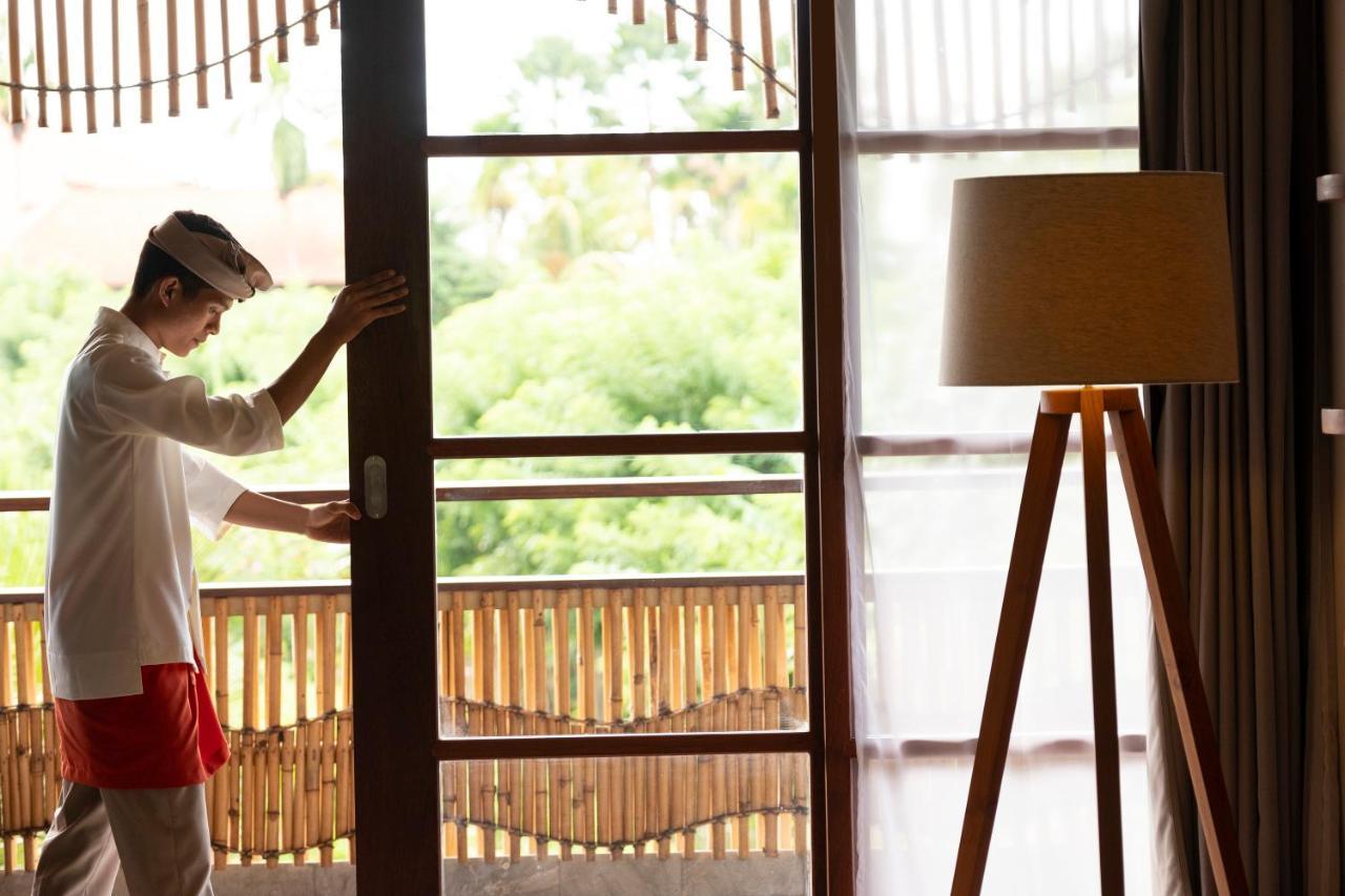 Alaya Resort Ubud Exterior foto A hotel staff opening a door